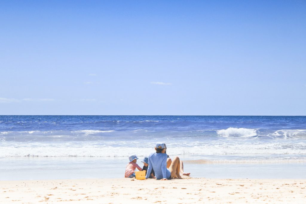 a group of people sitting on a beach