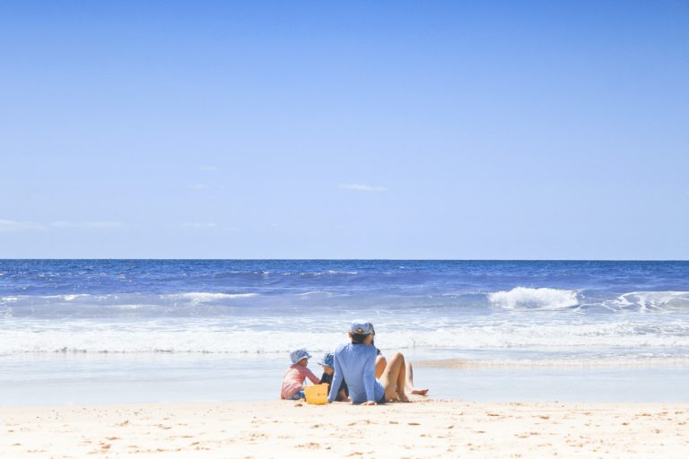 a group of people sitting on a beach