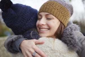 Two female friends, outdoors, hugging